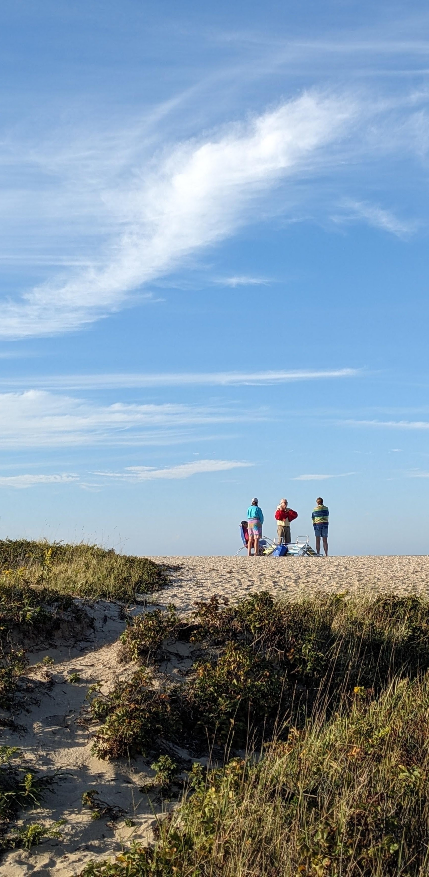 Sky, beach dunes, and four distant figures on the beach, Nantucket, MA, USA