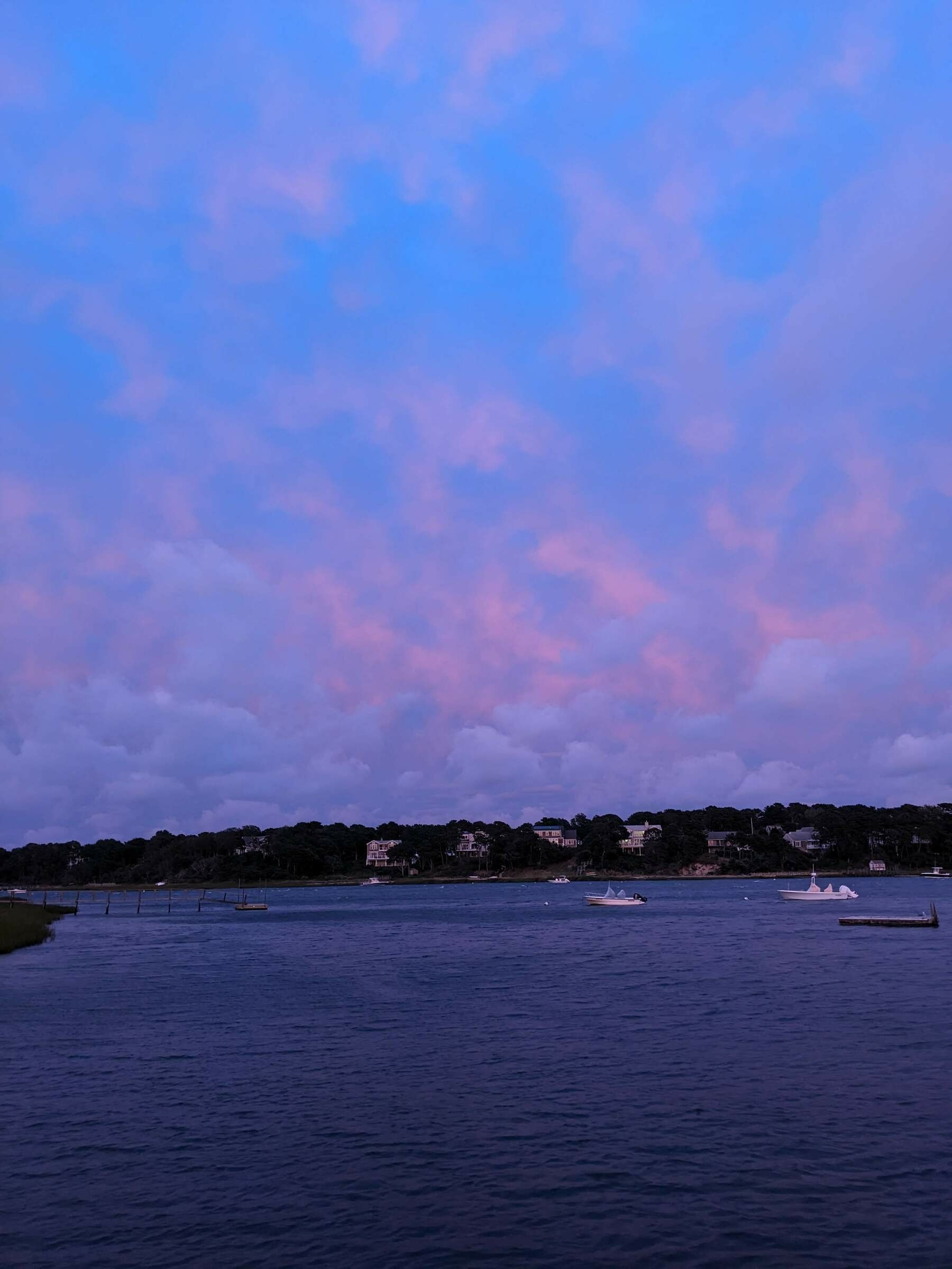 Pink clouds and deep blue sky over a Cape Code inlet at sunset.