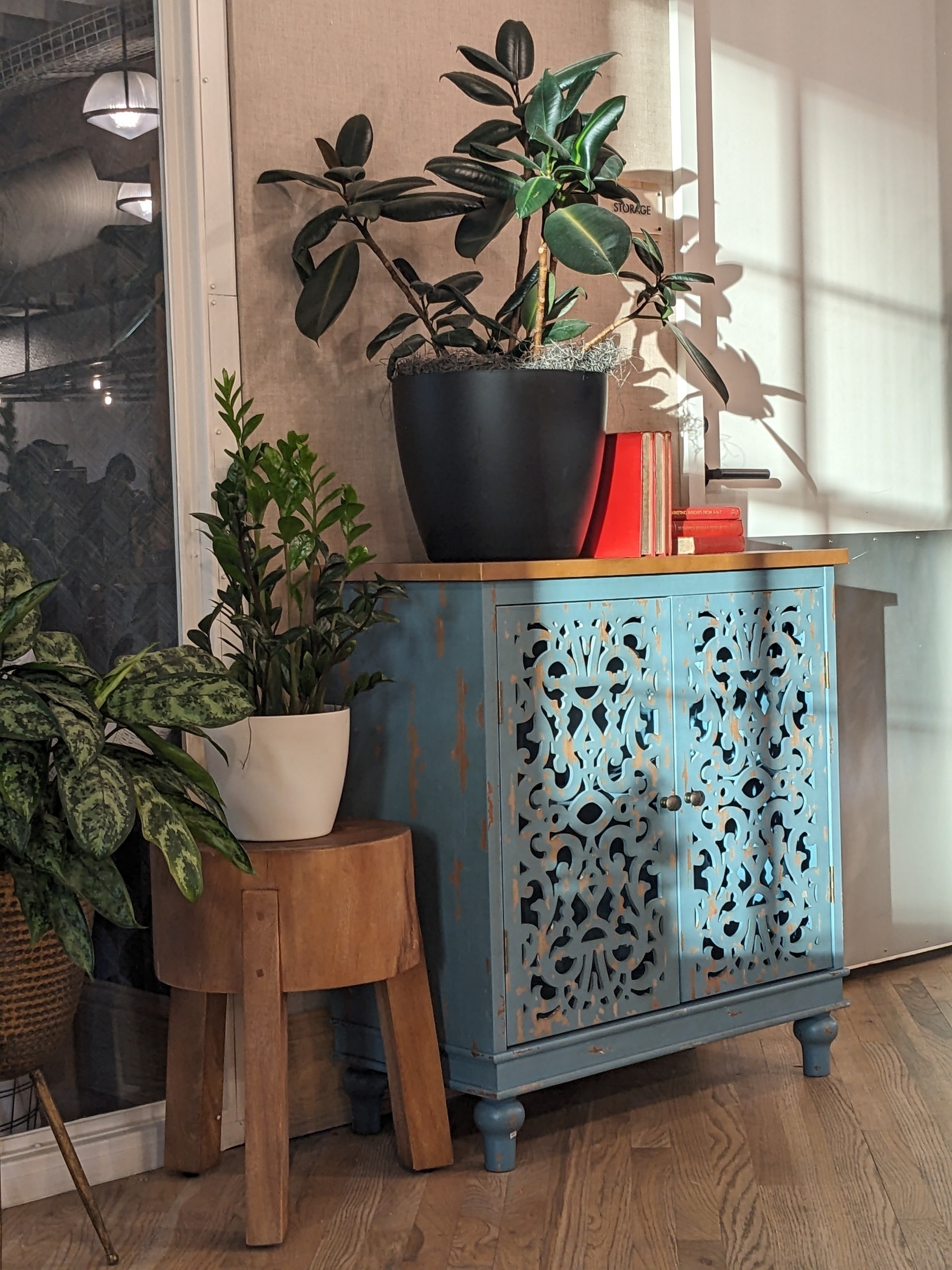 turquoise-colored chest with decorative wood work and plants on top