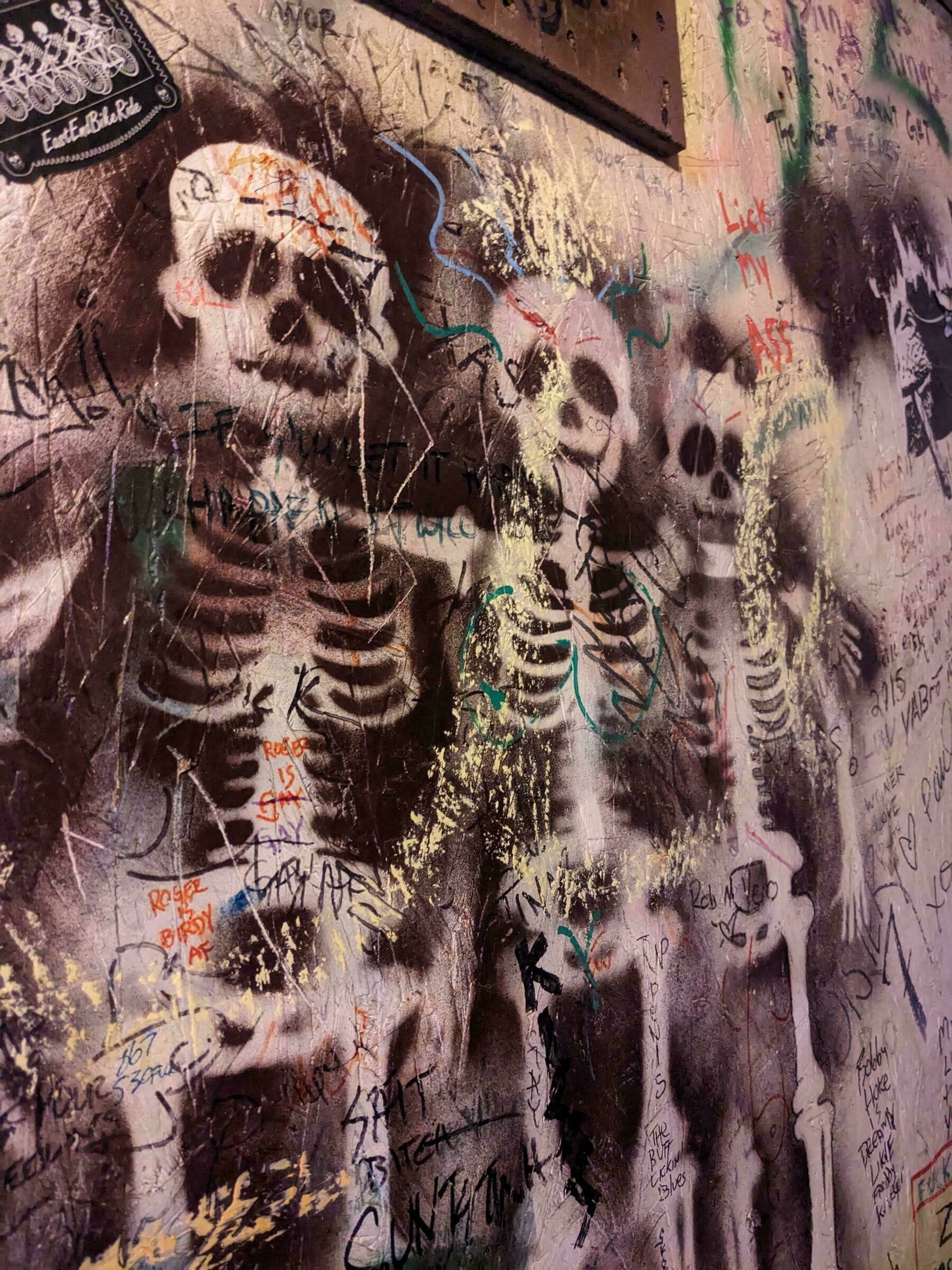 stenciled skeletons painted on a restroom wall